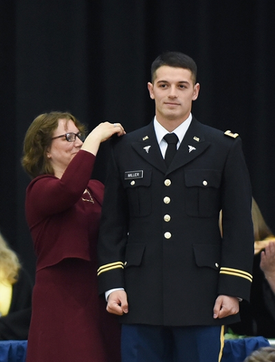 Jacob Miller's mother pins his bars during commissioning.