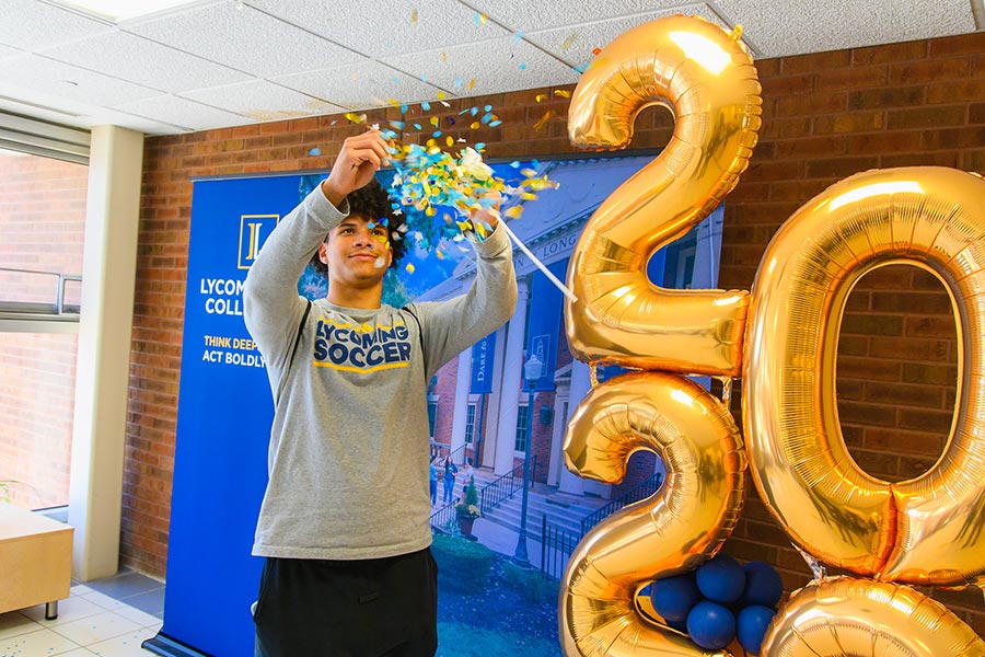 A student celebrating committing to Lycoming