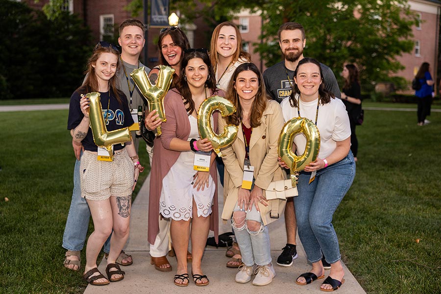 Alumni holding balloons that spell LYCO