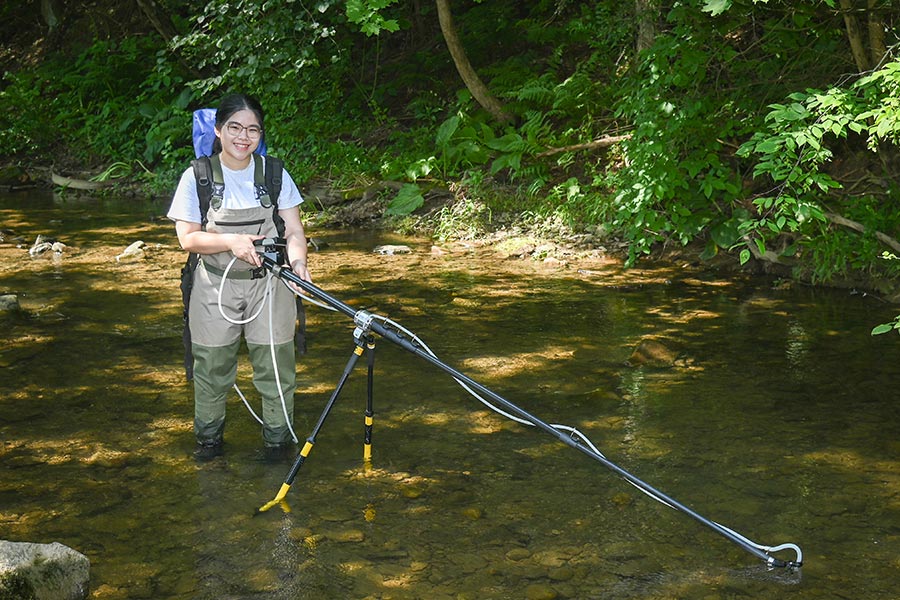 Student collecting data for ecology project in creek