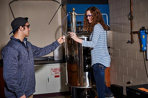 Cassandra Bendyk and Brandon Conrad load a sample into the 400 MHz NMR