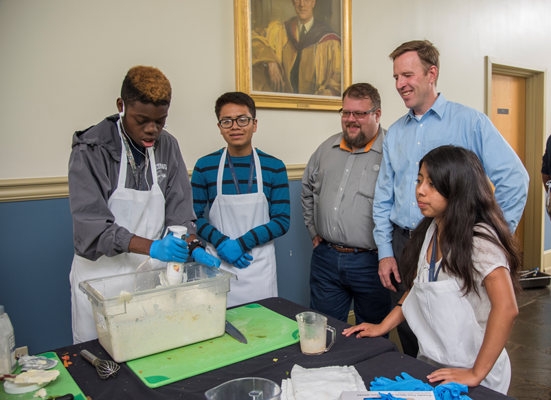 AT&T executives Sean Nork and David Kerr join Lycoming College Prep students for a cooking workshop.