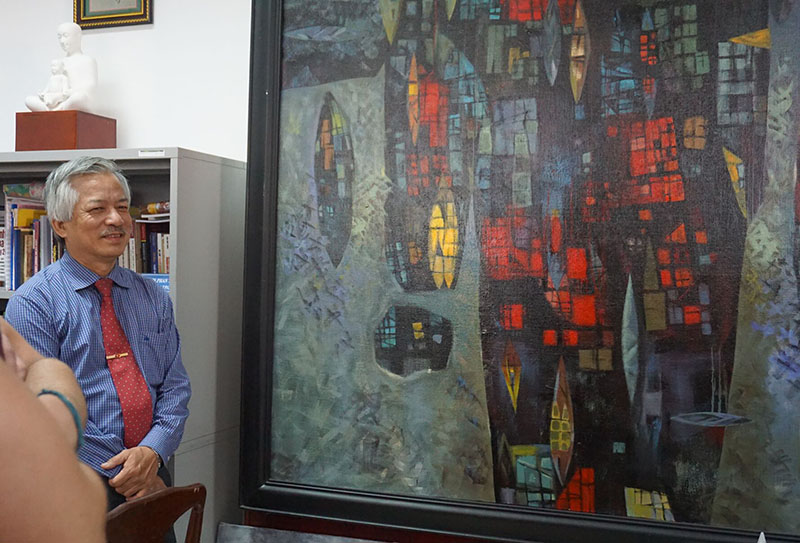 The director of the art school in Ho Chi Minh City shows the group his own paintings.